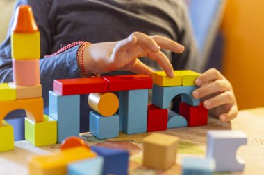 bir çocuk home.kid çalış, renkli tahta bloklar ile çalış ve inşa binalar ve kuleleri ile ahşap renkli bloklar.