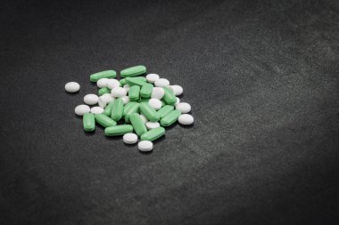 temiz siyah arka planda farklı beyaz, yeşil ve mavi haplar. birçok uyuşturucu ve onları kötüye ciddi zarar sağlık.