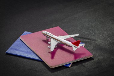 Uluslararası pasaport, kredi kartları ve bavul siyah bir arka planda uçak deseni. bir uçak uçuşu hazırlanması ve gerekli belgeler ve bunu yapmak için Araçlar.