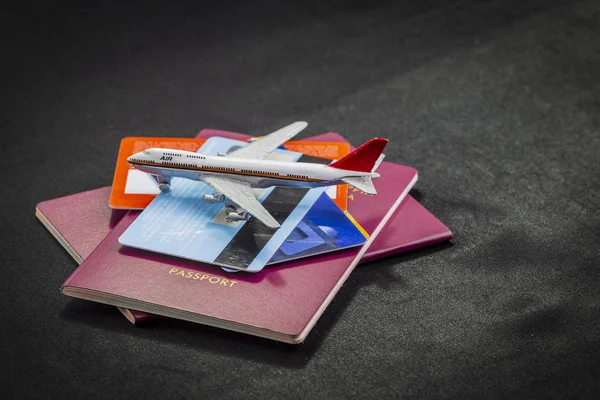 Uluslararası Pasaport Kredi Kartları Bavul Siyah Bir Arka Planda Uçak - Stok İmaj