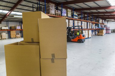 paket ve ihracat depolama Regal, karton ve forklift ile. Endüstriyel ambar ve mini fabrikada. yeni bir emtia ile doldurma için kartonlar.
