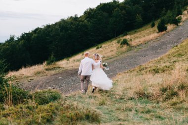 Güzel düğün çift, gelin ve damat, aşık dağların arka planda. Dağlarda düğün. Karpat dağlarının güzelliği, Ukrayna