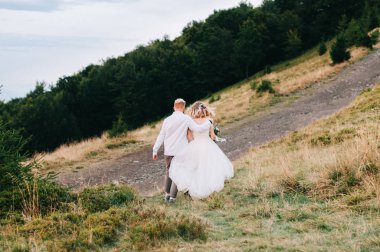 Güzel düğün çift, gelin ve damat, aşık dağların arka planda. Dağlarda düğün. Karpat dağlarının güzelliği, Ukrayna