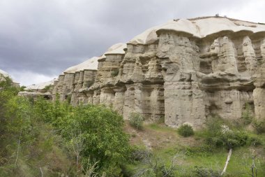 Kırmızı ve beyaz kumtaşı kayalıklarla, Kapadokya, Türkiye vadiler arasında bir dağ manzarası içinde antik mağaralar