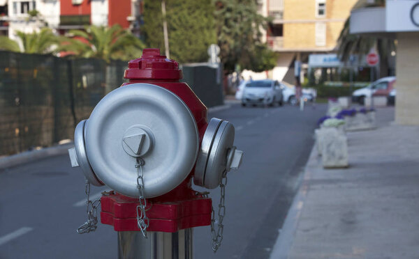 Head of a street fire hydrant with frosted steel caps against a city street