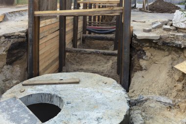 Beton bloklar, kuyu ve boru metal kiriş ve kurulları ile takviyeli şehir toplayıcı hendek sokak anayol üzerinde kazdık