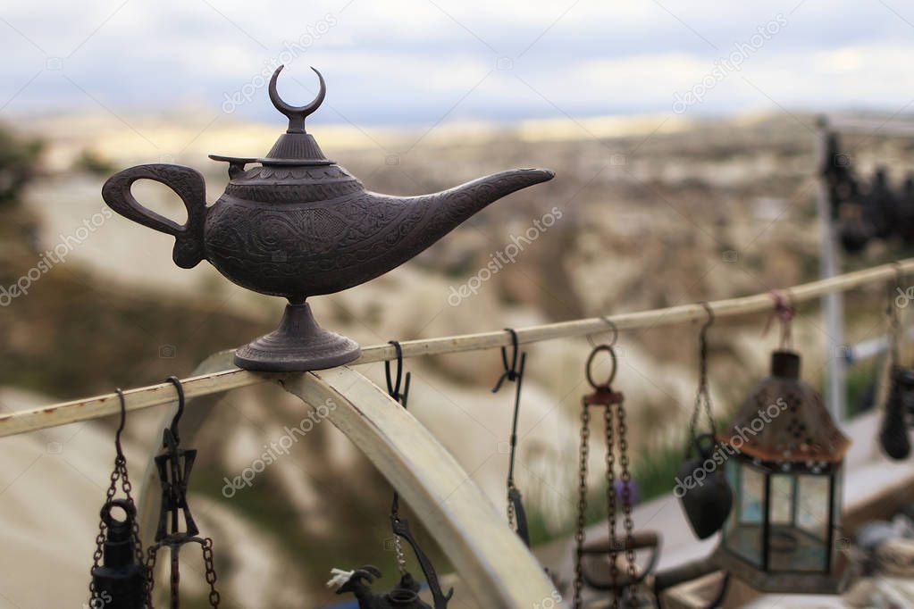 Old brass oil lamp oriental gin on a blurred background of different antiquities
