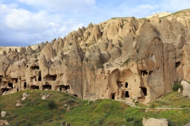 Eski antik yerleşim konik sırtlar, Kapadokya ve mavi bulutlu gökyüzü arka plan üzerinde mağaralar