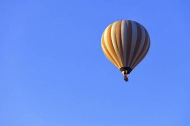 Ve yangın alev rengarenk bir sarı-beyaz güzel balon havada ısıtır ve mavi gökyüzü turistlere bir sepet yükseltir.