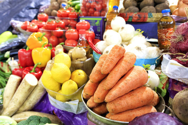 The vegetable market sells many different vegetables, such as carrots, tomatoes, onions, beets, potatoes, parsley roots, parsnips, eggplants, and lemons and sunflower oil.
