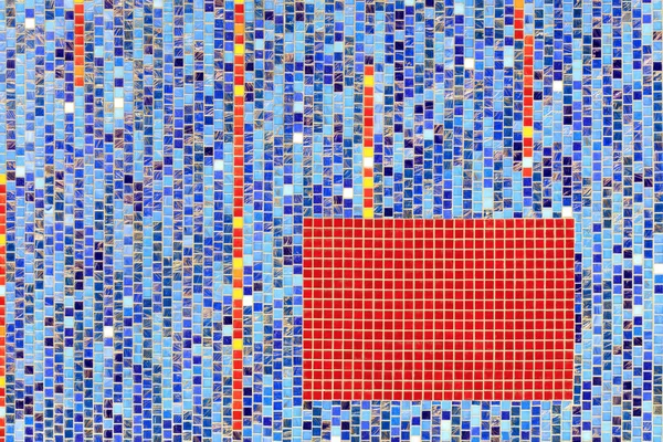 On the wall lined with blue ceramic mosaic the selected fragment is lined with red mosaic.