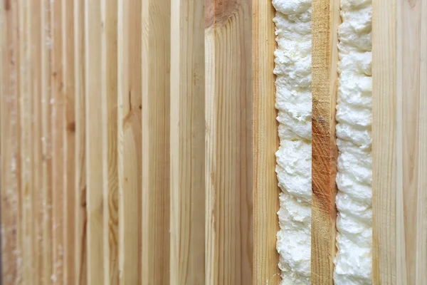 Пример заполнения промежутка между вертикальными деревянными досками строительной пеной . — стоковое фото