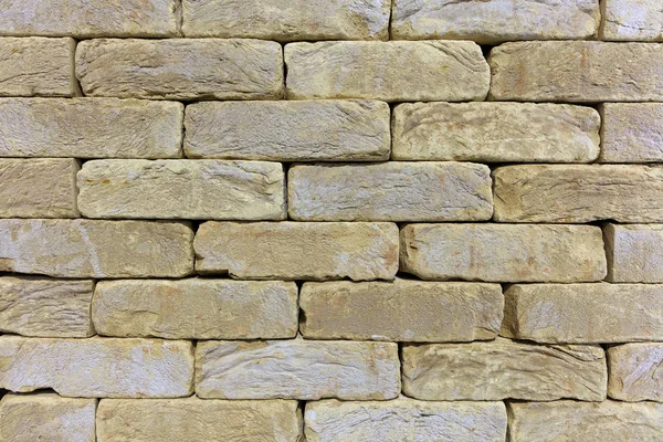 A textúra a kőfal, a régi tégla épület kő, homokkő bézs-arany. — Stock Fotó