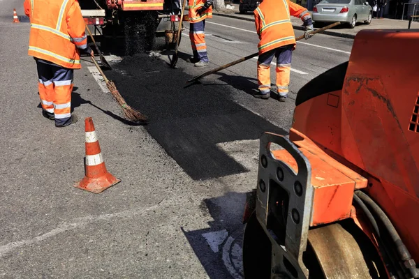 El equipo de trabajo actualiza parte del asfalto en el tramo cercado de la carretera . — Foto de Stock