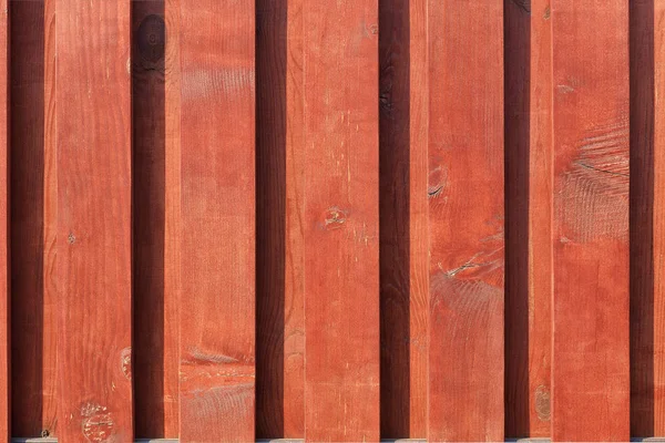 Текстура нового коричнево-красного деревянного забора в лучах солнечного света . — стоковое фото