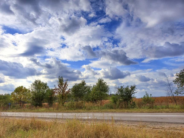 Пейзаж дороги на блакитне небо і збирання грози хмари в літній день . — стокове фото