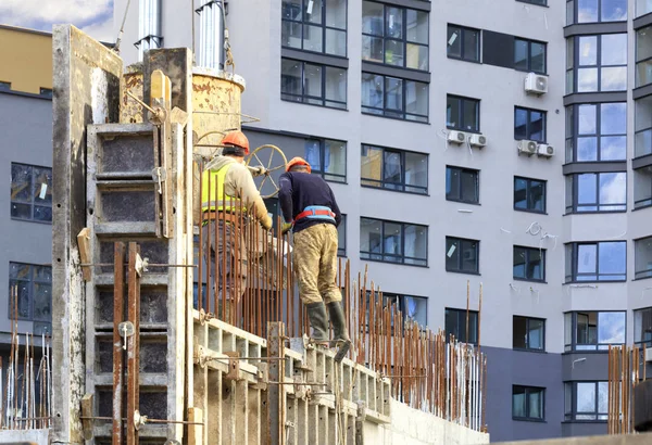 Lavoratori versato calcestruzzo nella cassaforma delle pareti una costruzione di casa — Foto Stock
