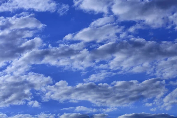 白い雲が明るい飽和青空に浮かぶ — ストック写真