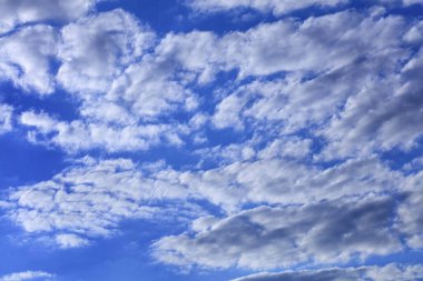 Beyaz bulutlar parlak doymuş mavi gökyüzünde yüzer