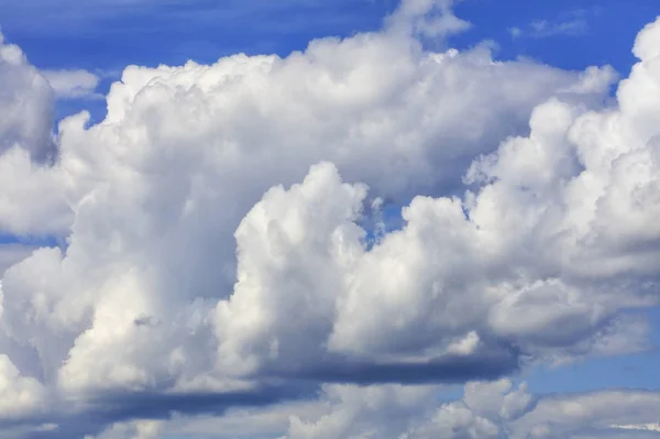 Weiß-graue große Wolken verdichten sich zu einer Regenwolke am blauen Himmel, Nahaufnahme. — Stockfoto