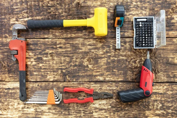 Een frame op een oud houten oppervlak gemaakt van een versleten handgereedschap. — Stockfoto