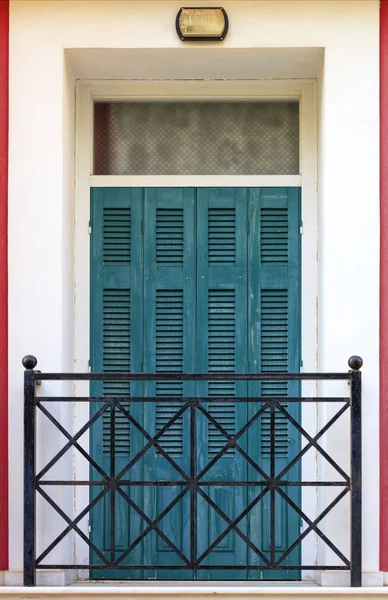 Velho verde portas de madeira varanda com persianas de madeira e barras de metal no estilo grego varanda . — Fotografia de Stock