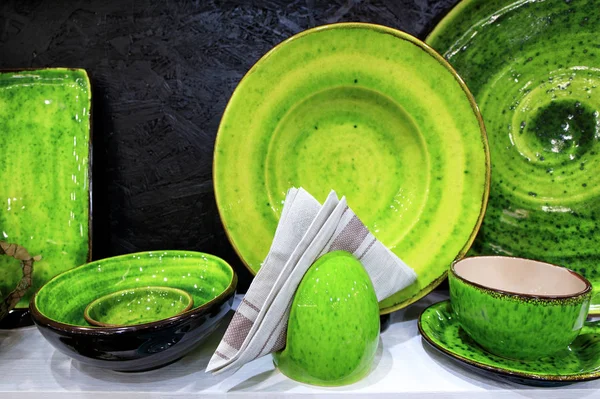 Фланелевая салфетка и набор керамики покрыты ярко-зеленой глазурью . — стоковое фото