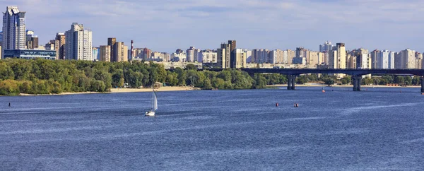 Landscape: the Dnipro River, residential areas of Kyiv on the banks and the old bridge over the river in bright sunlight. — Stock Photo, Image