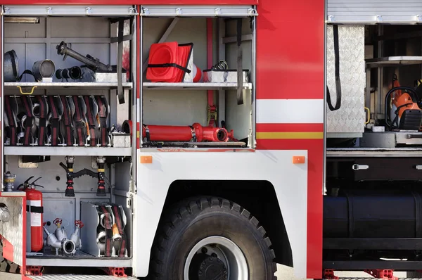 Fire hoses, valves and cranes, transport cones, manual fire extinguishers are located in the cargo compartment of an equipped fire truck.