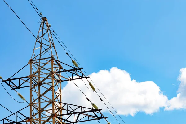 白い雲と青い空の背景に対する架空送電線をサポートするために使用される絶縁体とワイヤと金属電源ラインのサポート コピースペース — ストック写真