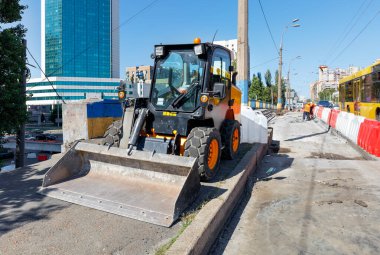 Şehir caddesinde asfalt yolun onarımı sırasında bir buldozer..