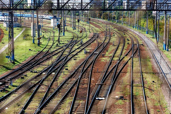 An extensive multi-channel rail network for trains, diagonal perspective and rhythm, top view through the fence mesh.
