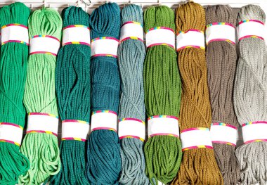 Çeşitli parlak renklerde polyester kablo ruloları yeşil ve bej, katlanmış, yakın plan, kopyalama alanı.