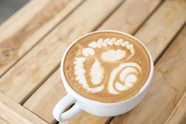 カプチーノ アート コーヒーのコーヒー ショップで木のテーブルに牛乳から作られた — ストック写真