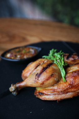 Siyah çanak ahşap arka plan üzerinde ızgara tavuk