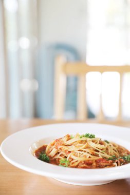 Parmesan peyniri ve fesleğenle süslenmiş kıyma ve domates soslu spagetti bolonez, İtalyan yemeği.