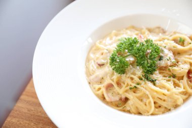 Pastırma ve sarımsak, ahşap masa arka plan ile makarna beyaz sos (spagetti Carbonara)