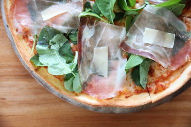 Pizza parma ham salata roket üzerinde ahşap masa arka plan ile domates sosu ile