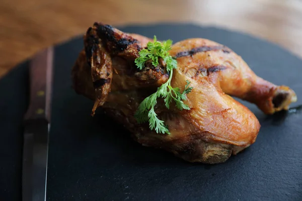 Siyah çanak ahşap arka plan üzerinde ızgara tavuk