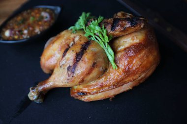 Siyah çanak ahşap arka plan üzerinde ızgara tavuk