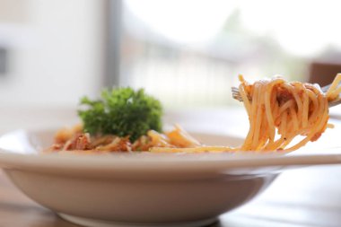 Parmesan peyniri ve fesleğenle süslenmiş kıyma ve domates soslu spagetti bolonez, İtalyan yemeği.