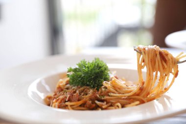 Parmesan peyniri ve fesleğenle süslenmiş kıyma ve domates soslu spagetti bolonez, İtalyan yemeği.