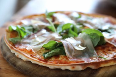 Pizza parma ham salata roket üzerinde ahşap masa arka plan ile domates sosu ile