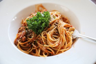 Parmesan peyniri ve fesleğenle süslenmiş kıyma ve domates soslu spagetti bolonez, İtalyan yemeği.