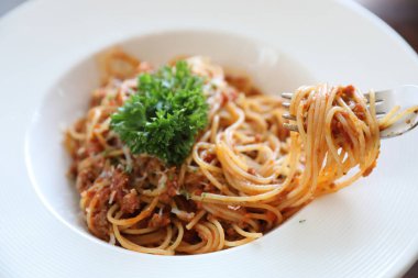Parmesan peyniri ve fesleğenle süslenmiş kıyma ve domates soslu spagetti bolonez, İtalyan yemeği.