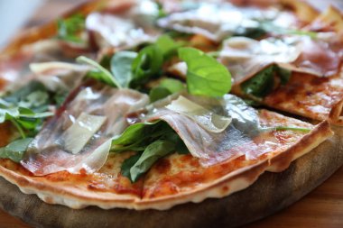 Pizza parma ham salata roket üzerinde ahşap masa arka plan ile domates sosu ile