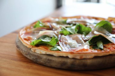 Pizza parma ham salata roket üzerinde ahşap masa arka plan ile domates sosu ile