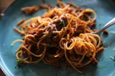 Spagetti Bolognese kıyma ve domates sosu ile parmesan peyniri ve fesleğen, İtalyan yemeği üstten görünüm ile süslenmiş
