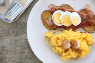Sahanda yumurta, kızarmış patates pastırma ve karides ile kahvaltı