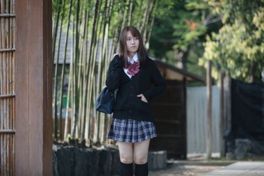 Portrait Asian japanese school girl costume looking in japanese garden  clipart